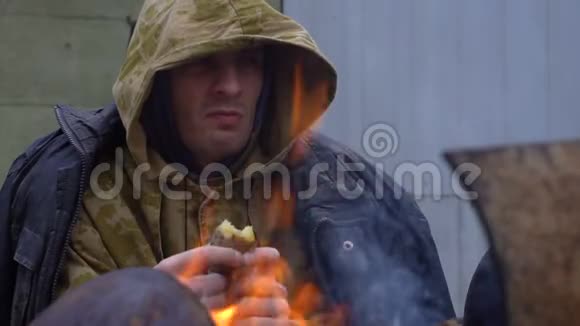 无家可归的人在火炉旁吃东西视频的预览图