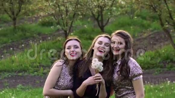 三个女孩在花园里吹蒲公英慢慢地视频的预览图