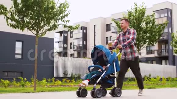 在城里带着婴儿车和咖啡的父亲视频的预览图