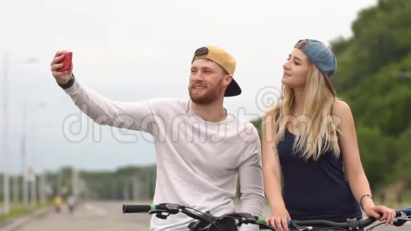 幸福的年轻夫妇笑着骑自行车慢动作视频的预览图