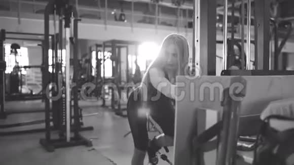 强壮的金发女人在健身俱乐部锻炼举重视频的预览图