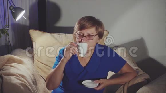 坐在椅子上喝茶的老妇人视频的预览图
