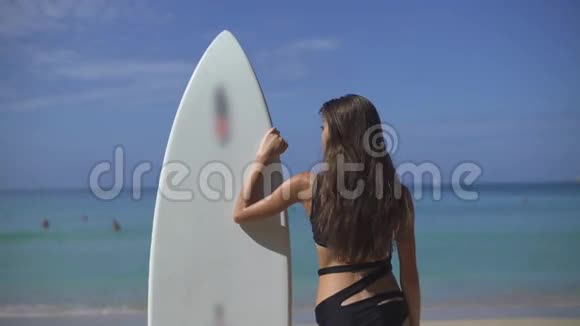 美丽的女性冲浪者寻找波浪视频的预览图