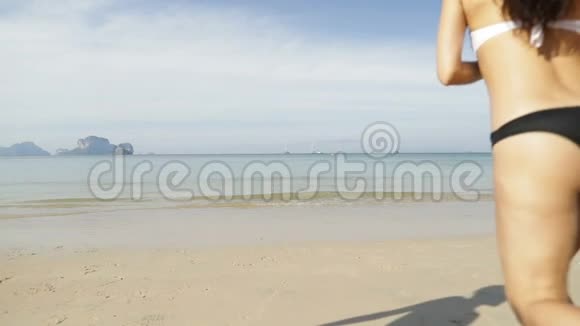 女孩和两对情侣牵手在水中奔跑人们在海滩上观光视频的预览图