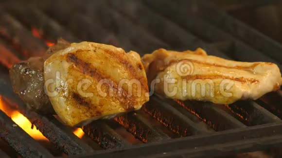 在烤架上放上牛肉和两块鸡片或火鸡的奖章背景是视频的预览图