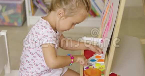 可爱的小女孩为她的画混颜料视频的预览图