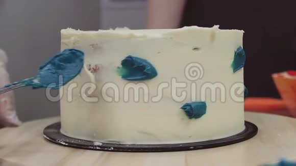 糕点厨师手工涂抹蓝色奶油白色糖霜视频的预览图
