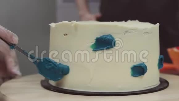 糖果手在白色糖霜上涂抹蓝色奶油视频的预览图