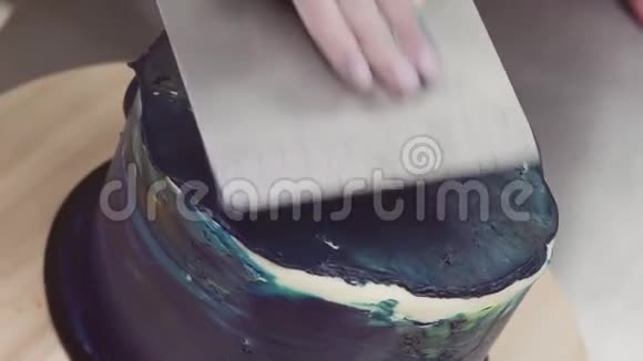 甜点主厨用糕点刮饼机用手抚平蓝彩锦缎视频的预览图