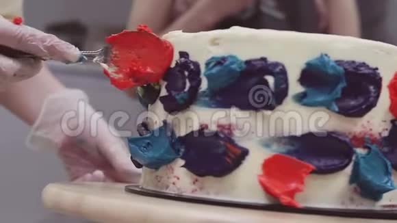 糕点厨师手把五颜六色的奶油糖霜在海绵蛋糕上用勺子视频的预览图