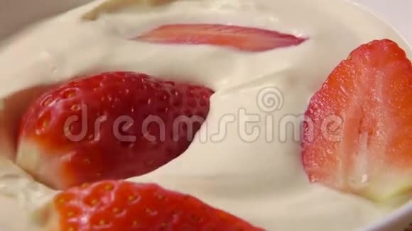 一片草莓和鲜奶油一起掉进罐子里视频的预览图