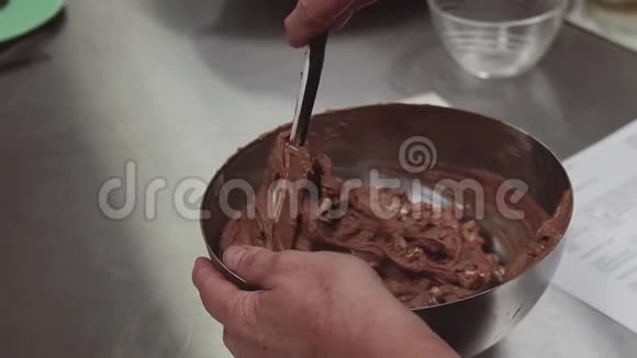 糖果手把巧克力面团混合在厨房的金属碗里视频的预览图