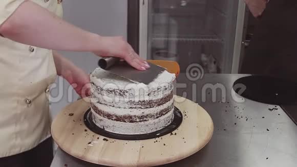 女性糕点师用糕点刮片取过多的奶油蛋糕视频的预览图