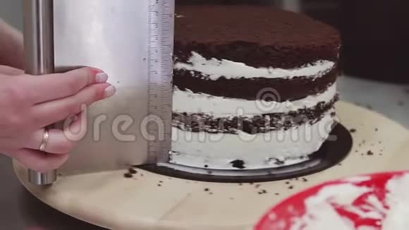 女性糖果师用糕点刮片取过多的奶油蛋糕视频的预览图