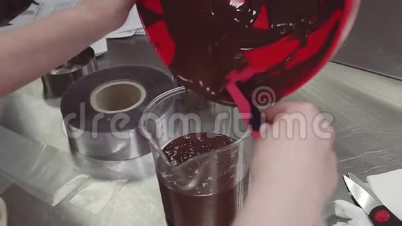 糕点厨师女手将融化的巧克力倒入量杯中视频的预览图