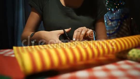 女性切割黄色与橙色条纹包装纸包装礼物视频的预览图