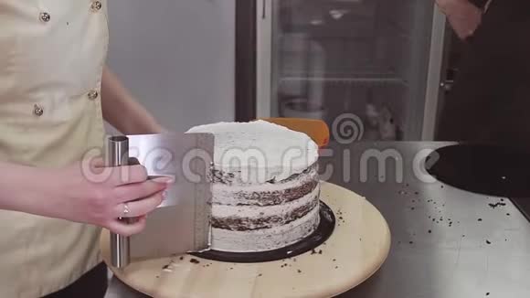 使用糕点刮饼机取过多奶油的女士糖果视频的预览图