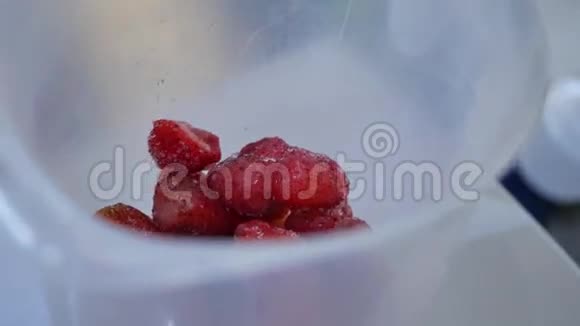 在一个公制杯子里给草莓切丁量杯中的草莓视频的预览图