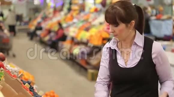 在农贸市场挑选水果的顾客视频的预览图