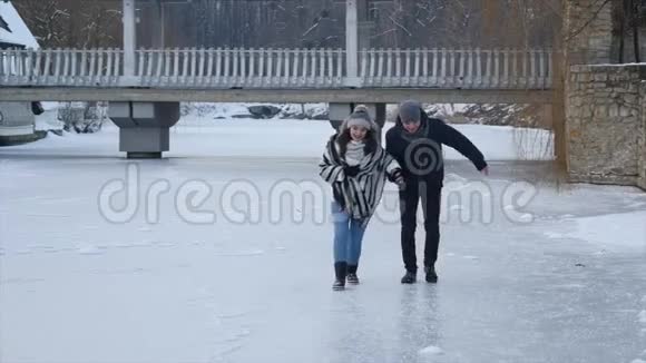 快乐的年轻夫妇在冰冻的湖面上滑冰视频的预览图