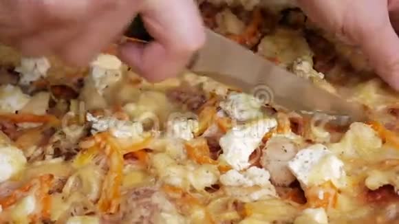 一个男人手切一块自制的披萨里面有不同的奶酪和西红柿移动摄像机视频的预览图