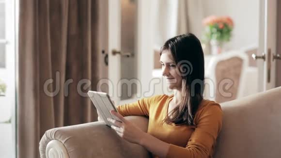 女人坐在沙发上拿着触控板视频的预览图