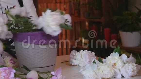 专业的花匠开始做一束粉红色的牡丹花关门视频的预览图