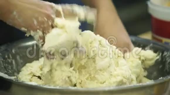 工业厨房用双手揉搓面团视频的预览图