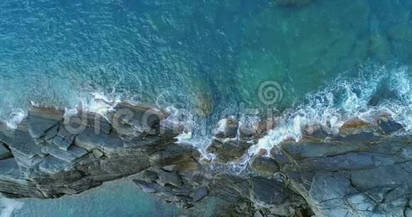 从空中俯瞰地中海海浪到达和撞击岩石海岸海滩海岸天气晴朗视频的预览图