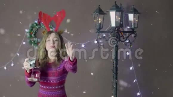 可爱的圣诞女孩戴着驯鹿角微笑着用复古相机拍照在圣诞节隔离视频的预览图