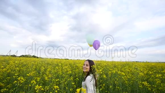 快乐的小女孩玩肥皂泡草地上的气球微笑的孩子在野外放松慢动作视频的预览图