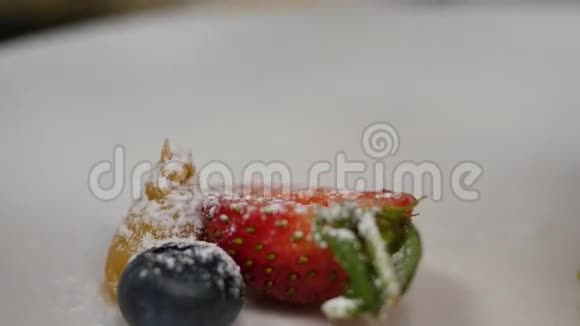 草莓和蓝莓与粉状糖洒在草莓蓝莓上撒粉视频的预览图