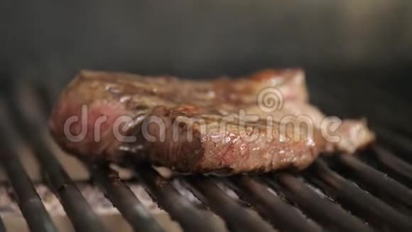 在烧烤上煎牛排典型的阿根廷烧烤或阿萨多烧烤架里的木头和红色的热煤视频的预览图