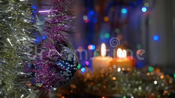 一个大蓝球挂在圣诞树上新年和圣诞装饰品燃烧蜡烛燃烧的视频的预览图