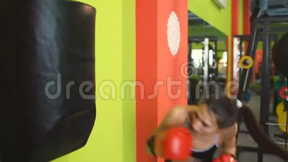 年轻女子拳击手在拳击俱乐部的赛前热身时打拳击袋视频的预览图