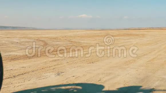 骑摩托车的人骑在沙滩上徒步旅行者骑摩托车穿过沙漠视频的预览图