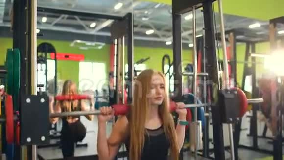 强壮的金发女人在健身俱乐部锻炼举重视频的预览图