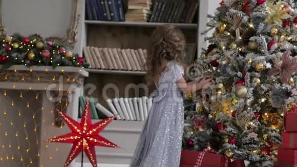 这个女孩正在用一辆火车装饰一棵圣诞树圣诞节室内视频的预览图