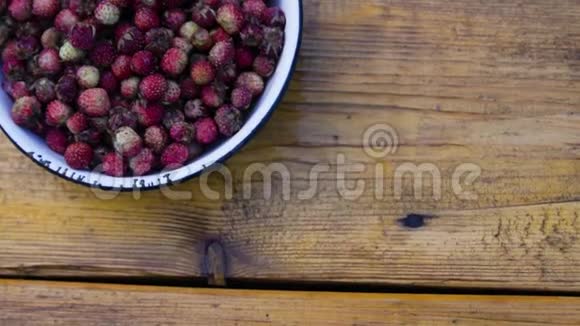 木制背景碗里的红色草莓视频的预览图