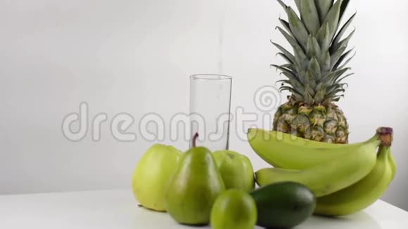 绿色成分由香蕉苹果菠萝和梨组成高的玻璃杯里装满了水视频的预览图