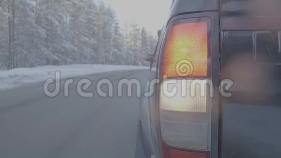 雪道上的大灯特写这辆车骑在白雪覆盖的道路上时间推移视频的预览图