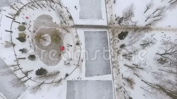 空中俯瞰城市冬季公园在冰冻的湖面上溜冰场冬天的家庭乐趣视频的预览图