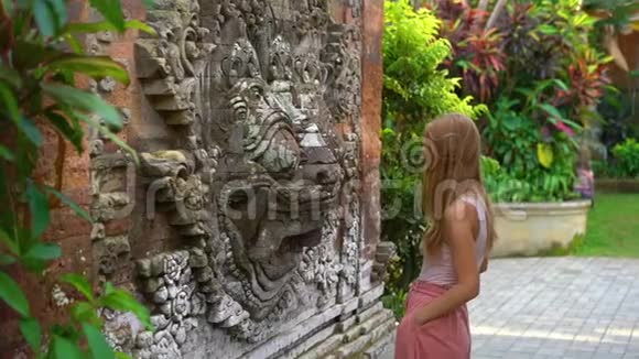 巴厘岛乌布村一位美丽的年轻女子参观普里萨伦皇家宫殿的慢镜头视频的预览图