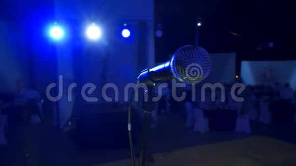 4的K型声乐麦克风站在礼堂或中庭的大舞台上背景是蓝色的肥皂视频的预览图