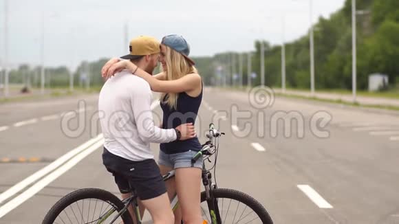 幸福的年轻夫妇笑着骑自行车慢动作视频的预览图