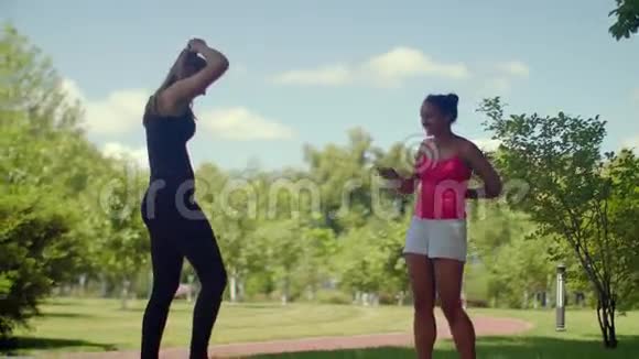 健身女孩在夏天在公园里聊天年轻的女性朋友视频的预览图