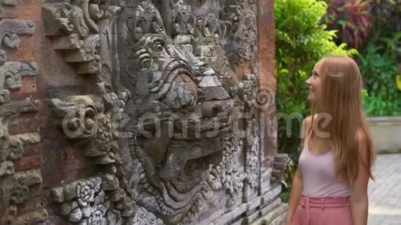 巴厘岛乌布村一位美丽的年轻女子参观普里萨伦皇家宫殿的慢镜头视频的预览图