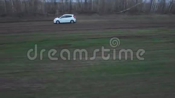 白色的汽车在田野上飞驰视频的预览图