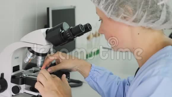在实验室里用显微镜工作的女人视频的预览图