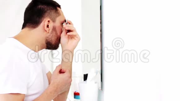 一个拿着镊子的男人在浴室里拧眉视频的预览图